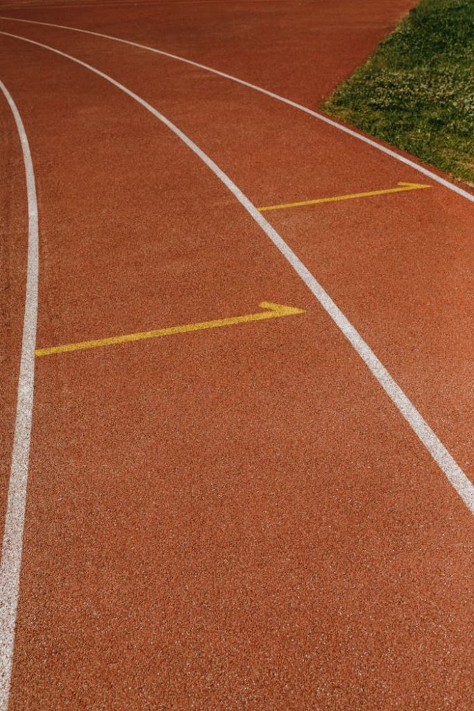 close-up-of-running-sports-track-8533631 Close-up of a curved athletic track with distinct yellow and white lane markings.